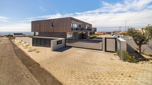 Un bâtiment moderne à deux étages, doté d’un toit plat, de grandes fenêtres et d’une allée pavée.