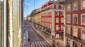 Vista de la calle con edificios, un paso de peatones y cielo despejado.