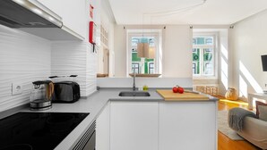 Una cocina moderna con estufa integrada, un lavamanos y una tabla de cortar de madera.