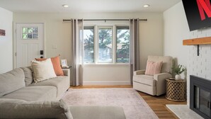 Una sala de estar con sofá, sillón y chimenea.