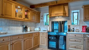A kitchen with wooden cabinets, a built-in oven, and a stainless steel range hood.