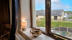 A room with a window, a radiator, a lamp, and a decorative bowl on the windowsill.