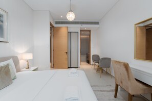 A hotel room with a large bed, a desk, a chair, and a wardrobe. - Modern 1BR w Marina View Balcony at Address JBR (Dubai)