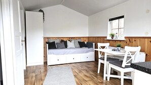 Une petite pièce comprenant un lit, une petite table et une chaise.