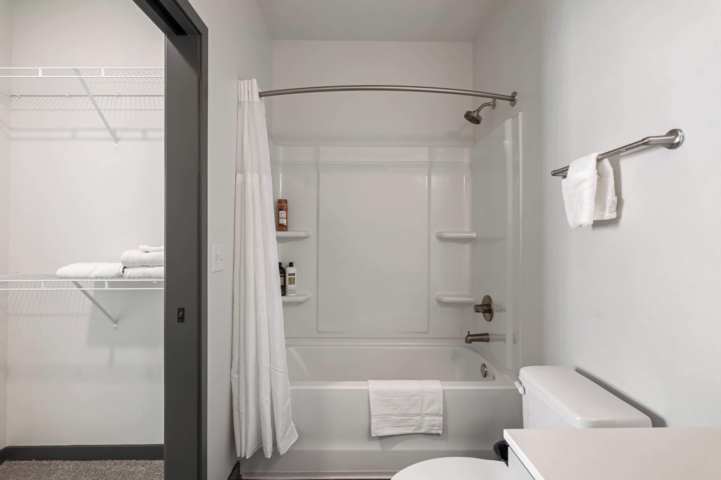 Une salle de bain moderne équipée d’une baignoire, de toilettes et d’un espace douche.