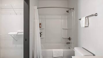 Une salle de bain moderne équipée d’une baignoire, de toilettes et d’un espace douche.