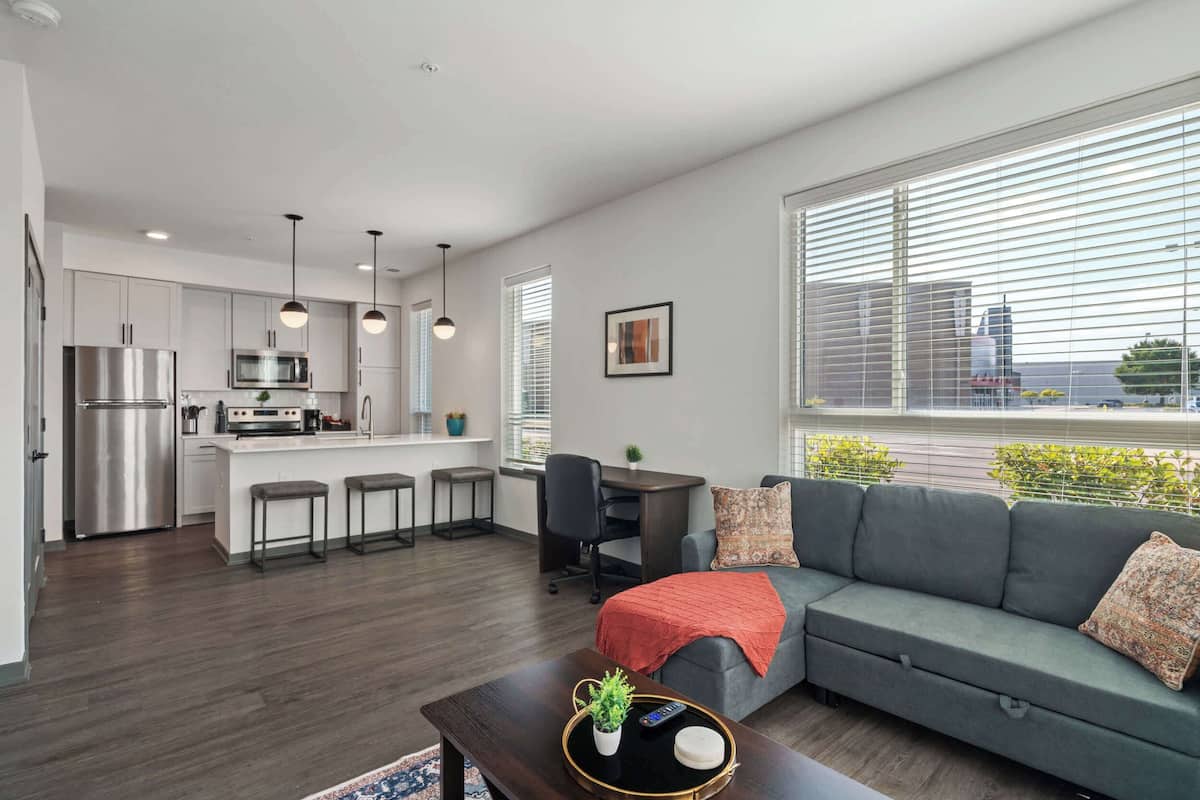 A modern apartment with a kitchen, dining area, and living room.