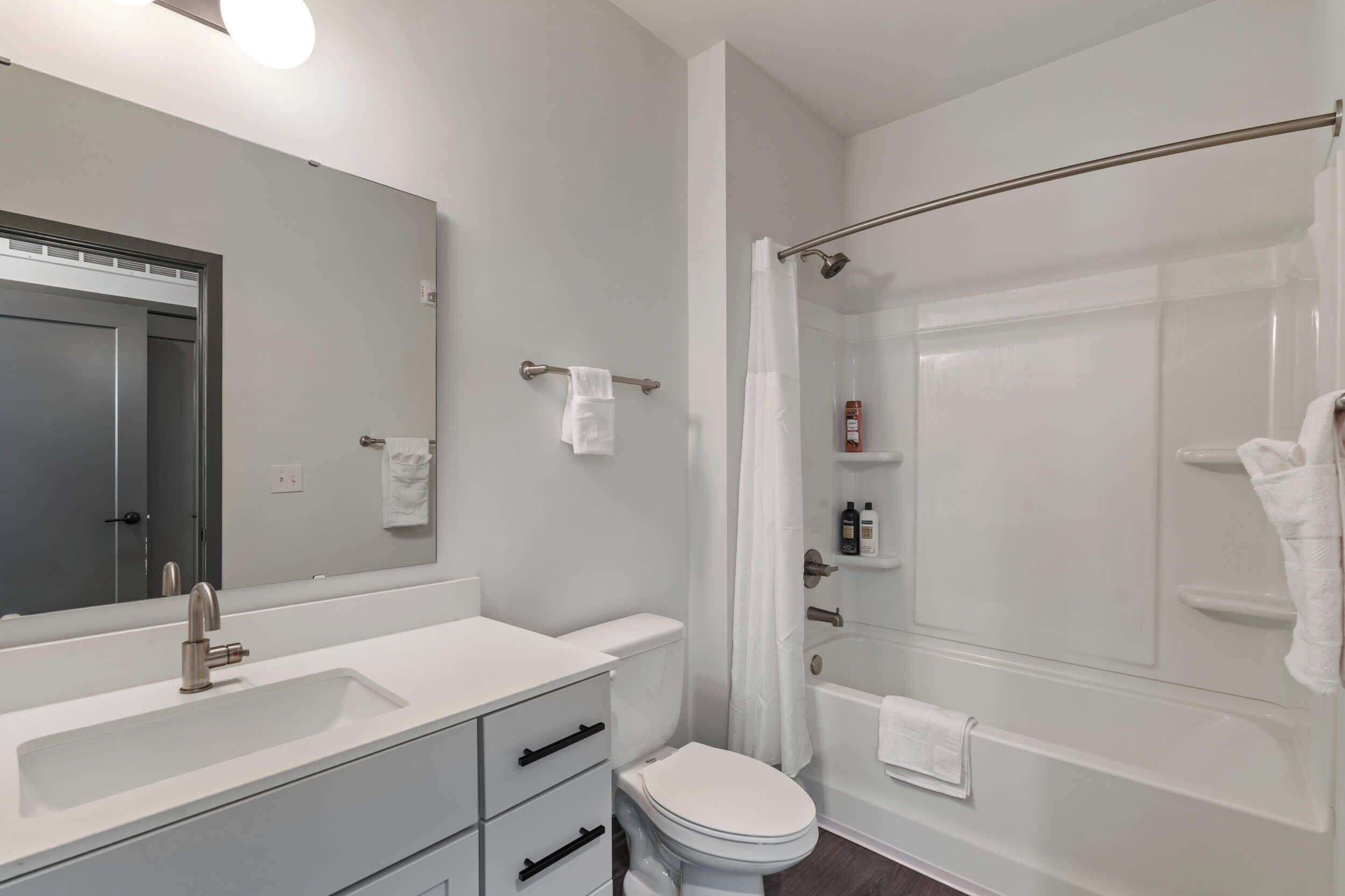 A modern bathroom with a sink, toilet, and shower area.