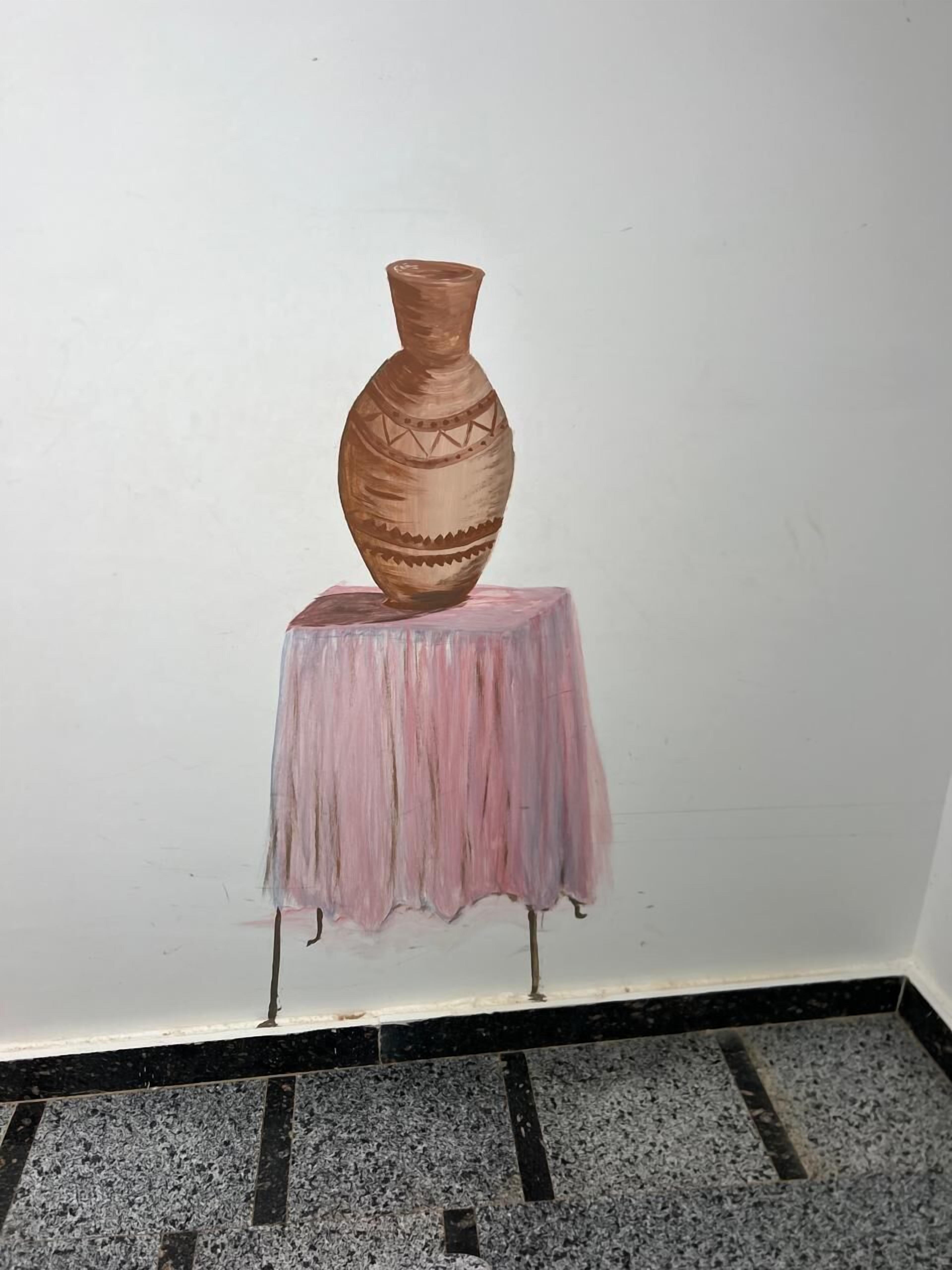 En vase står på et lille bord i et rum med flisegulv.