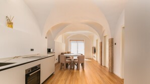 Una cocina moderna con comedor, suelo de madera y techo abovedado.