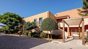 A cobblestone street leading to a building with a wooden pergola and a staircase. - Apartment 'Do Vale Holidays' with Shared Pool, Wi-Fi and Air Conditioning (Guia)