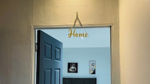 Un dormitorio con cama, mesita de noche, lámpara y luz empotrada en la pared.