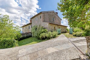 A stone building with a paved pathway leading to a gated entrance.