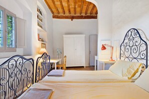 A bedroom with a bed, a desk, a chair, a wardrobe, and a radiator.