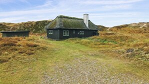 A rustic house with a thatched roof, surrounded by grassy terrain and hills. - "Asel" - 1km from the sea by Interhome (Fanø)