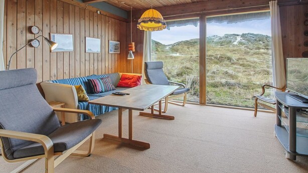 A cozy room with a wooden ceiling, a sofa with colorful cushions, a dining table, and a TV. - "Asel" - 1km from the sea by Interhome (Fanø)