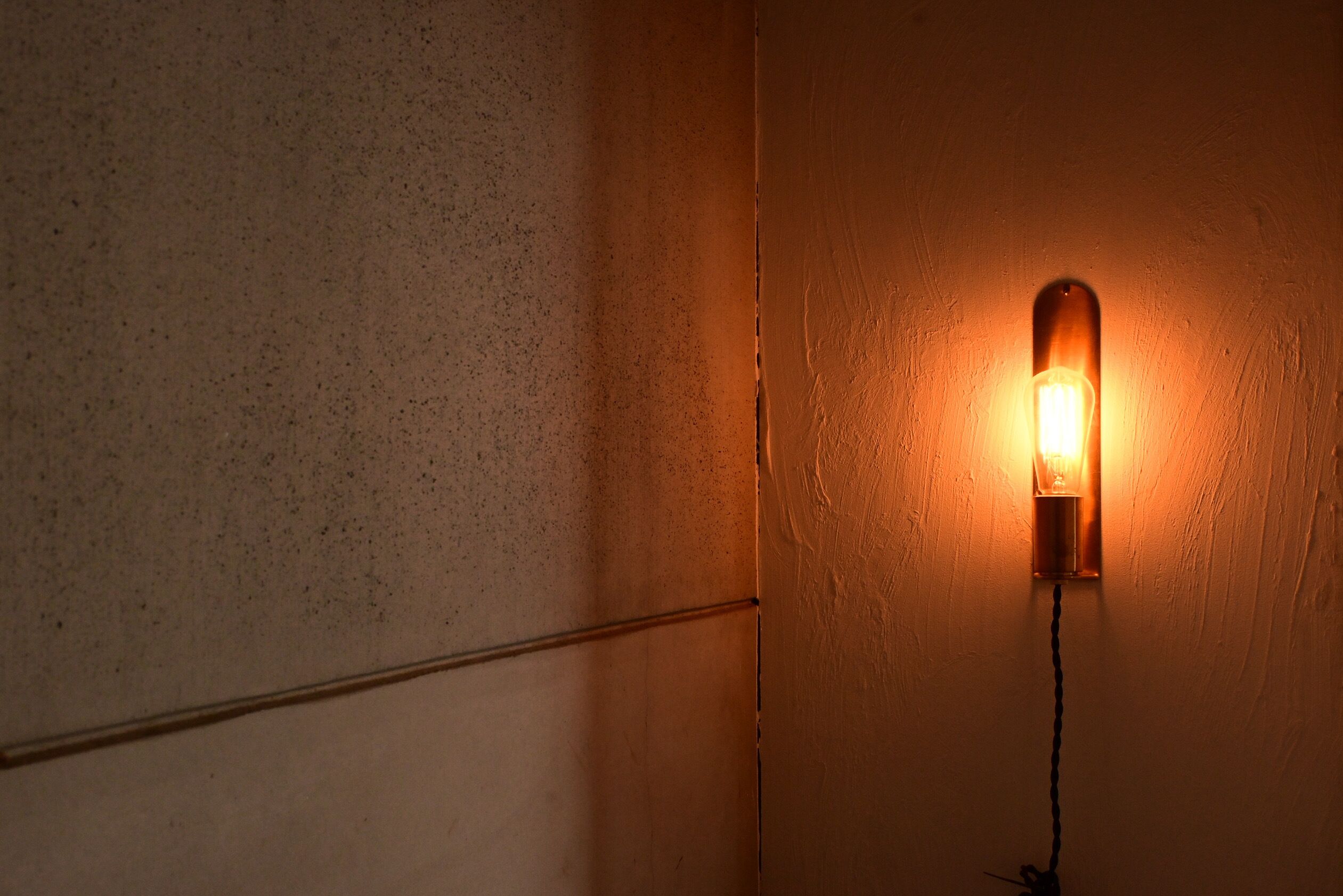 A wall-mounted light fixture with a visible power cord.