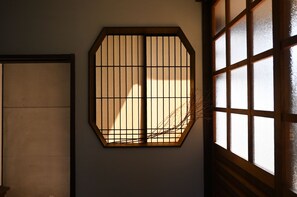 A room with a traditional Japanese shoji screen door and a window with a grid pattern.