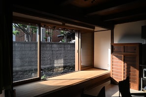 A traditional Japanese room with tatami flooring, a sliding shoji screen, and a built-in wooden cabinet.