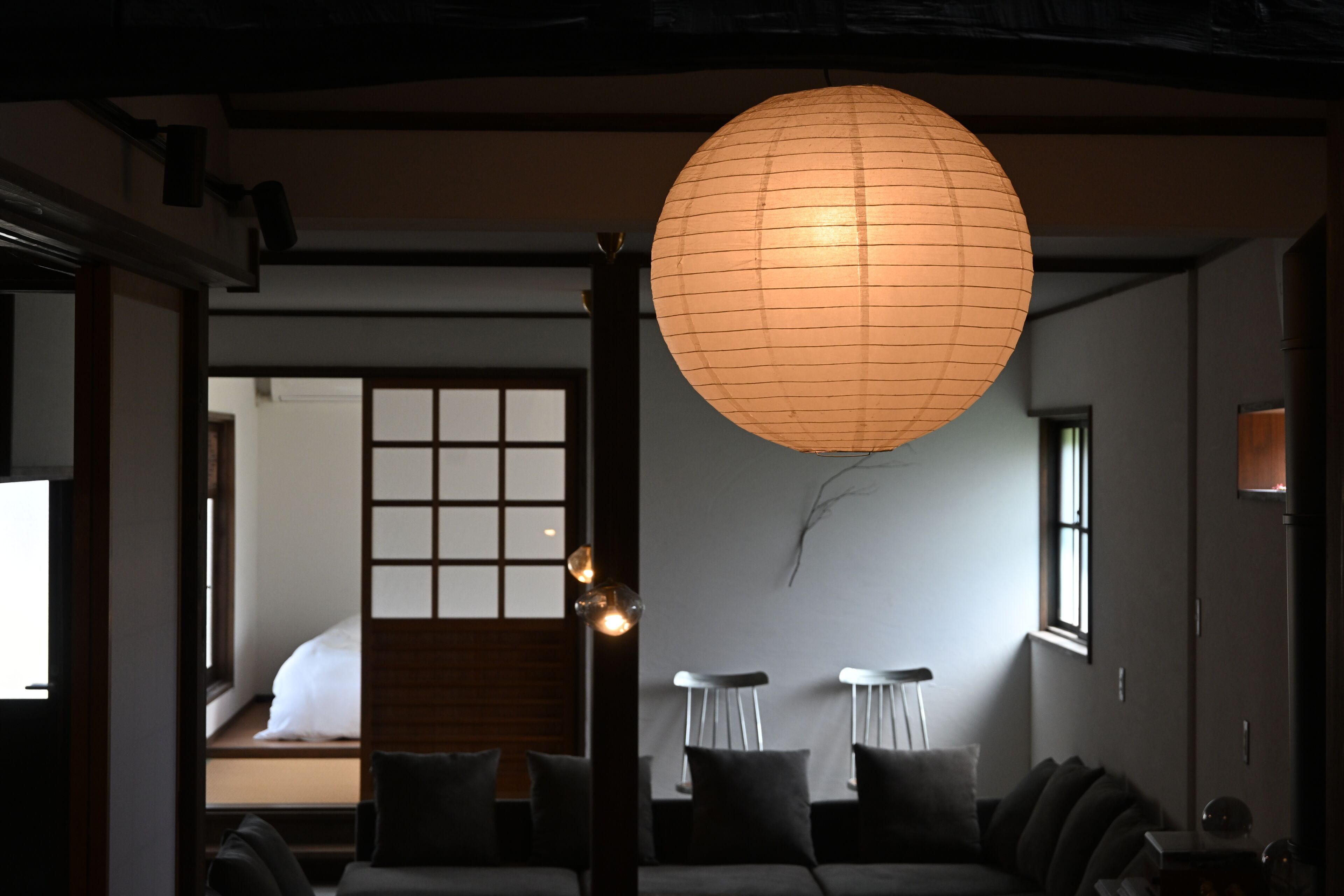 A traditional Japanese interior with tatami flooring, a low table, cushions, and a paper lantern.