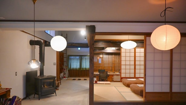 Una habitación tradicional japonesa con suelo de tatami, una mesa baja y un futón.