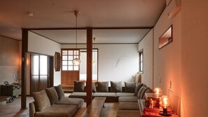 Una sala de estar moderna con un sofá modular, un banco de madera e iluminación colgante.