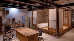 Una habitación tradicional japonesa con suelo de tatami, una mesa de madera baja y un futón.