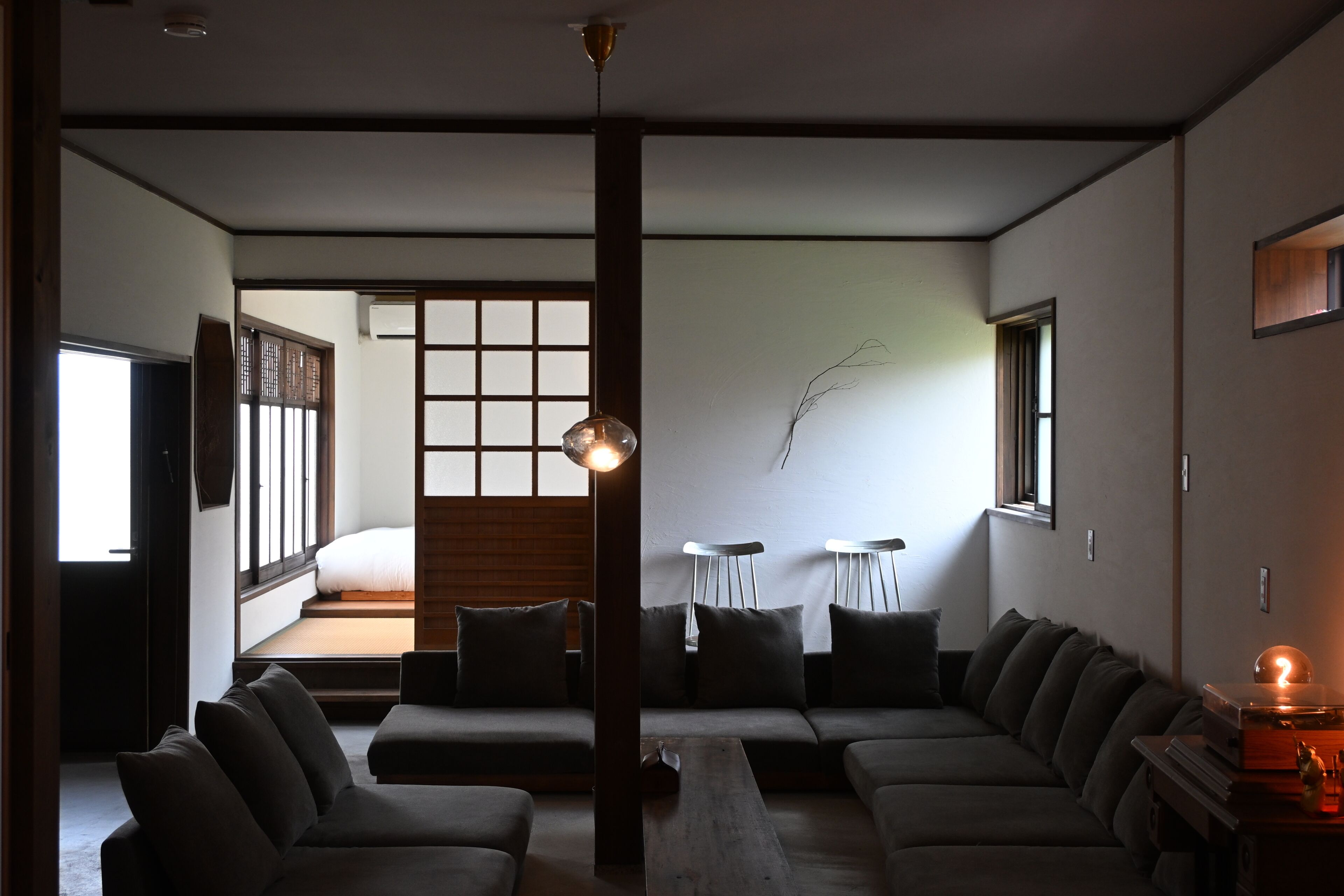 Un salon moderne comprenant un ensemble de canapés, une table basse et un petit coin repas avec deux chaises.