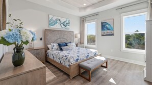 A bedroom with a bed, a bench, a nightstand, a vase with flowers, and a ceiling fan. - 5 Kings-Private Backyard Oasis, Pool/Spa/Turbo Slide-Beach (Panama City Beach)