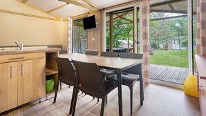 Una cocina moderna con comedor, ventanas amplias y televisor.