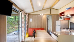 Una cocina moderna con armarios de madera, un comedor con mesa y sillas, y vistas a una terraza.