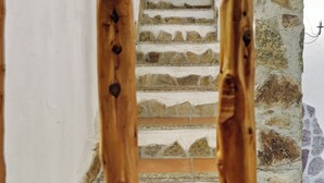 A staircase with stone walls and wooden balusters.