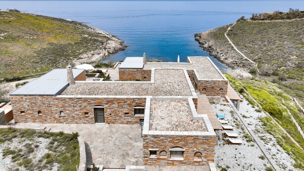A coastal building with stone walls and a rooftop terrace overlooking the sea. - Clio Apartment Kea (Otzias)