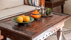 A room with a wooden bed, a bedside table with a fruit bowl and a lamp, and a window with curtains. - Superior Room Oasis (Marrakesh)