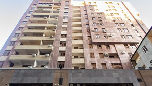 A high-rise building with multiple balconies and large windows.