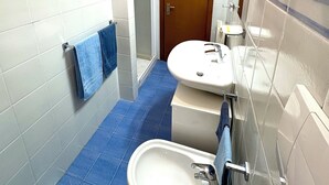 Une salle de bain avec deux lavabos, une douche et des toilettes.
