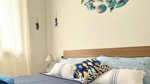 Une chambre à coucher avec un lit, des oreillers et une couverture bleue.
