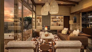 A modern interior with a fireplace, seating area, and large windows offering a city view.