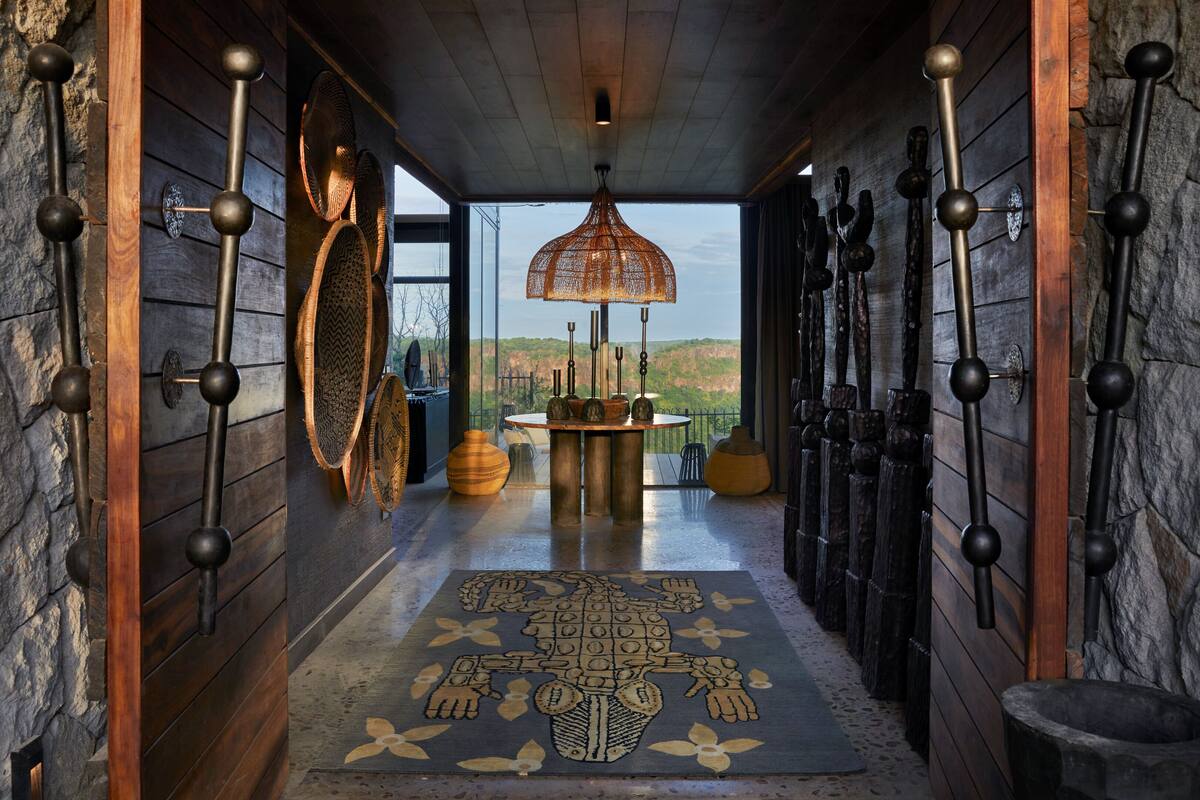 A hallway with wooden walls, a patterned floor, and a view of the landscape.
