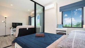 Een moderne slaapkamer met een bed, een bureau en een groot raam.