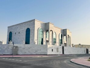 A modern building with a symmetrical facade, large arched windows, and a flat roof. - Travel Hub Near Business Bay By Al Taj (Dubai)