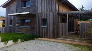 A two-story wooden house with a covered porch and a number '66' sign.