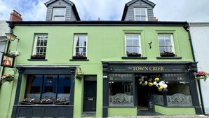 A green building with a sign reading "The Town Crier" restaurant. - The Town Crier (Tenby)