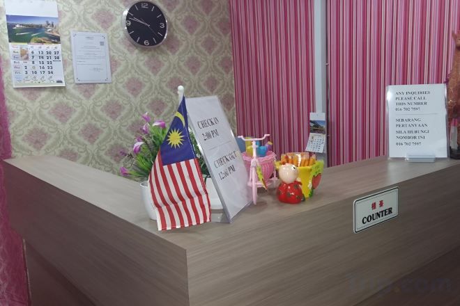 A reception desk with a clock, a flag, and a sign indicating the counter area.