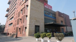 A multi-story building with a prominent sign indicating a new opening. - DEVENTURE HOTEL (New Delhi)