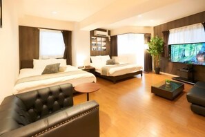 A hotel room with a bed, a sofa, a TV, and a small table. - S’CASA Nishishinjuku (Tokyo)
