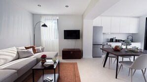 Un salon moderne comprenant un canapé, une table basse et un coin repas avec une table et des chaises.