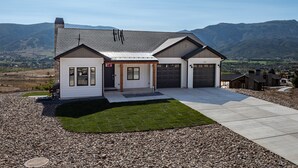 A two-story house with a garage, a front porch, and a well-maintained lawn. - Mountain View Retreat B11|Hot Tub |Near Powder Mtn (Eden)