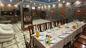 Un comedor con una larga mesa dispuesta para una comida, rodeada de sillas.