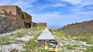 A stone pathway leading to a building with a view of the sea. - Lena Apartment Kea (Otzias Kea)